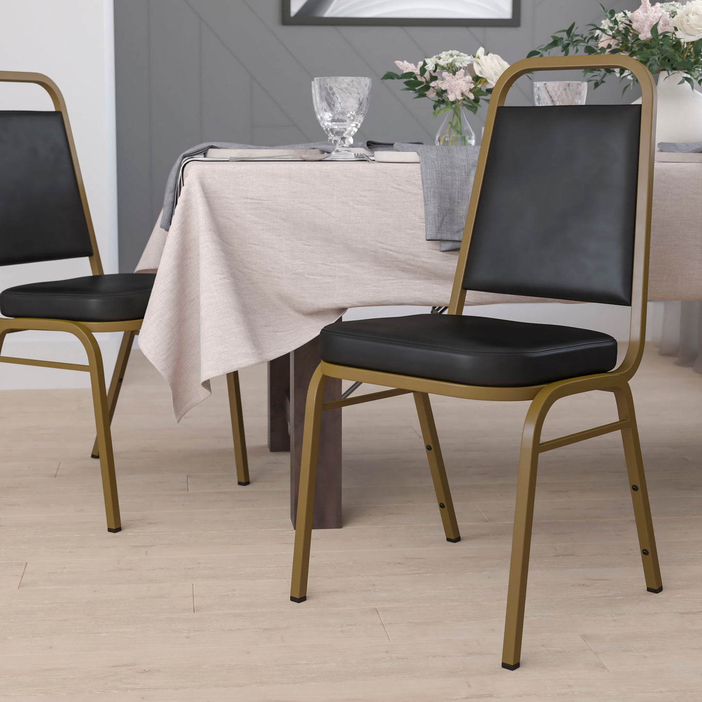 HERCULES Series Trapezoidal Back Stacking Banquet Chair in Black Vinyl - Gold Frame Black Vinyl/Gold Frame